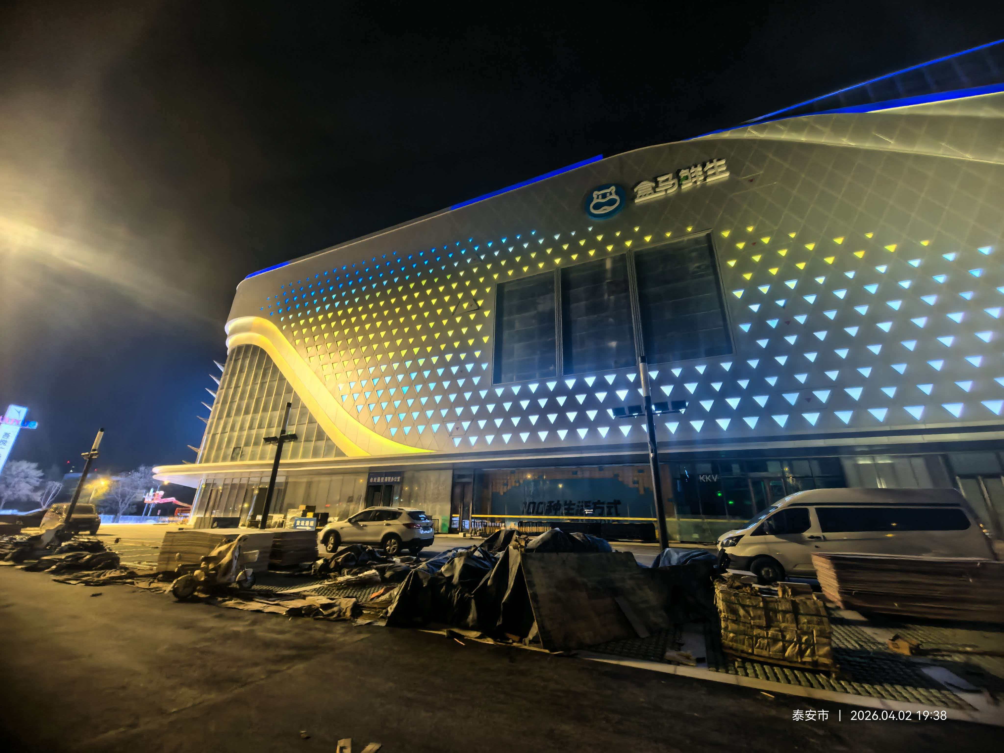 Tấm dẫn sáng hình tam giác tùy chỉnh và kết cấu mặt tiền LED màu xanh lam trên Feicheng Wuyue Plaza với logo Hema Fresh.